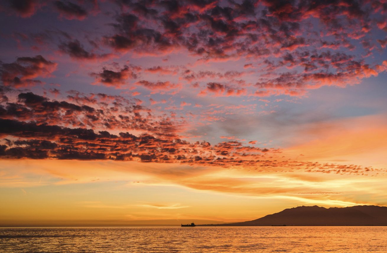 Coucher de soleil sur l'eau, ciel rose et orangé